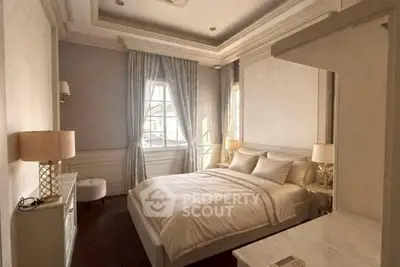 Luxurious bedroom with elegant decor and natural light, featuring a plush bed and stylish furnishings.