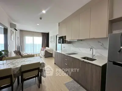 Modern open-plan kitchen and living room with stylish decor and natural light.