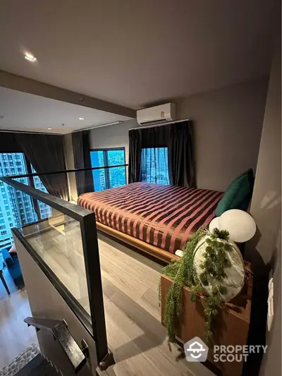 Modern loft bedroom with city view and stylish decor in high-rise apartment.