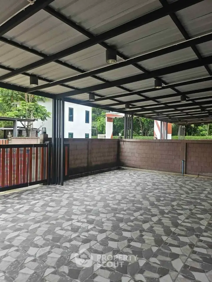 Spacious covered outdoor area with modern design and tiled flooring, perfect for gatherings.
