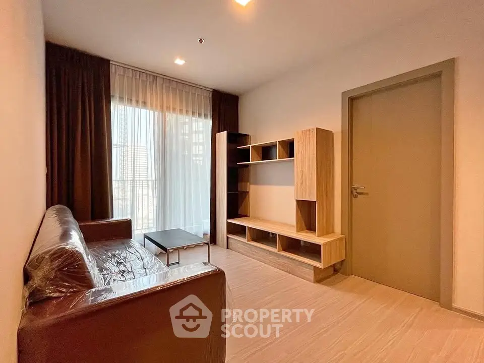 Modern living room with sleek furniture and large window for natural light.