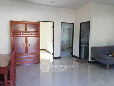 Spacious living room with wooden furniture and tiled flooring