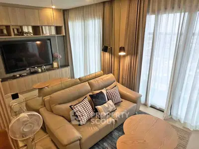 Modern living room with cozy sofa, stylish decor, and large windows offering natural light.