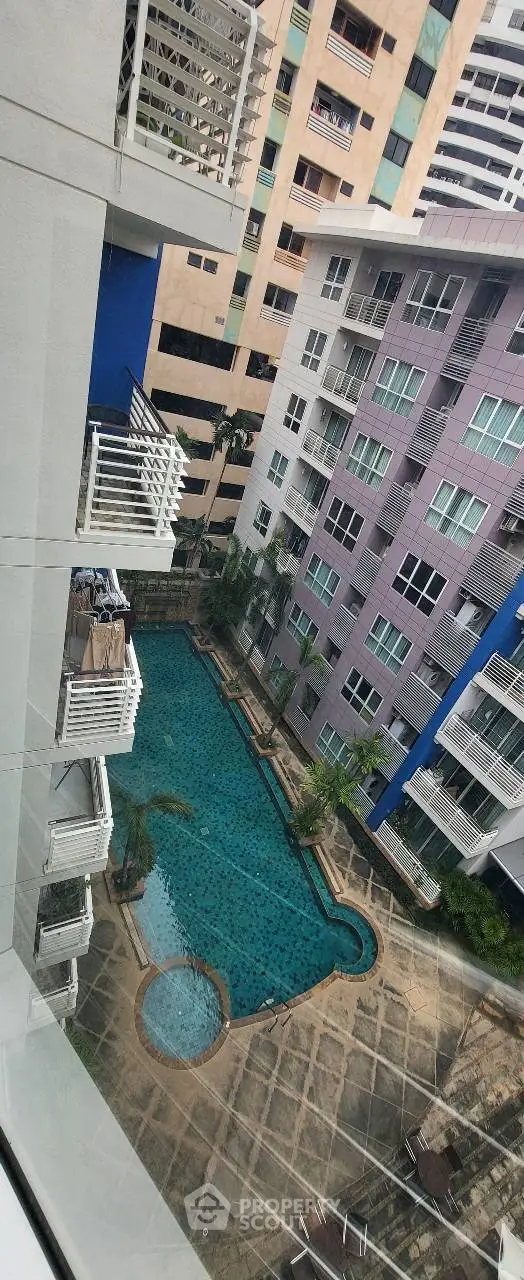 Stunning aerial view of modern apartment complex with inviting swimming pool and lush surroundings.