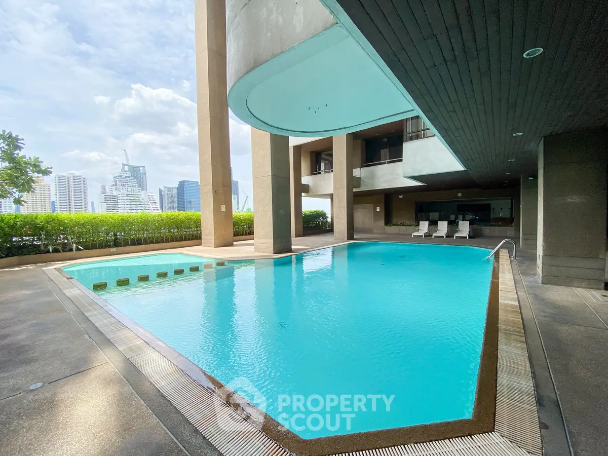 Luxurious rooftop pool with stunning city views in modern high-rise building.
