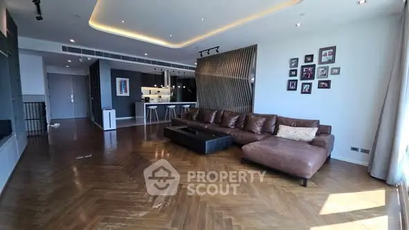 Spacious modern living room with elegant wooden flooring and stylish open kitchen.