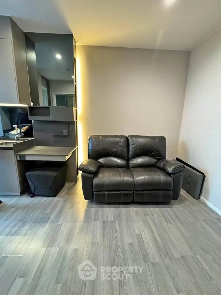Modern living room with sleek black leather sofa and stylish wooden flooring