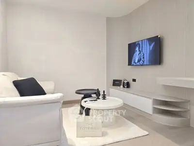 Modern living room with sleek design, featuring a wall-mounted TV and stylish furniture.