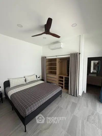 Modern bedroom with sleek design, featuring a spacious bed, built-in wardrobe, and ceiling fan for comfort.