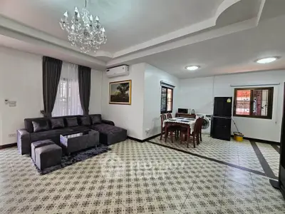 Spacious living and dining area with elegant chandelier and modern furnishings.