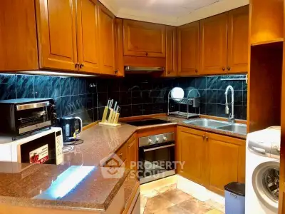 Charming kitchen with wooden cabinets, modern appliances, and sleek countertops.
