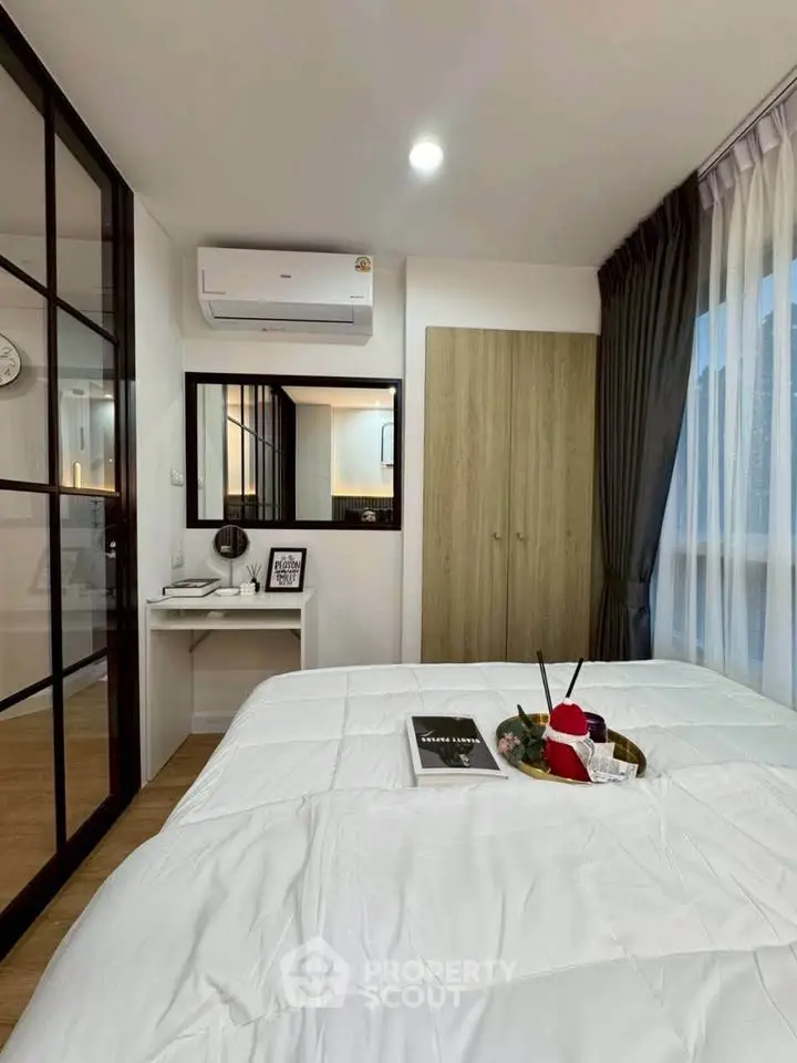 Modern bedroom with stylish decor and natural light, featuring a cozy bed and sleek furnishings.