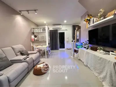 Modern living room with cozy seating and stylish decor, featuring a sleek entertainment center and ambient lighting.