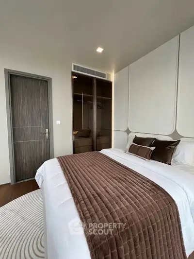 Luxurious bedroom with elegant decor and plush bedding in modern apartment.