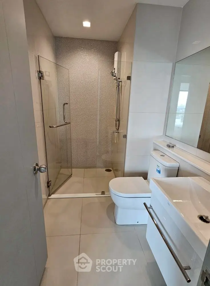 Modern bathroom with glass shower and sleek fixtures in a contemporary apartment.