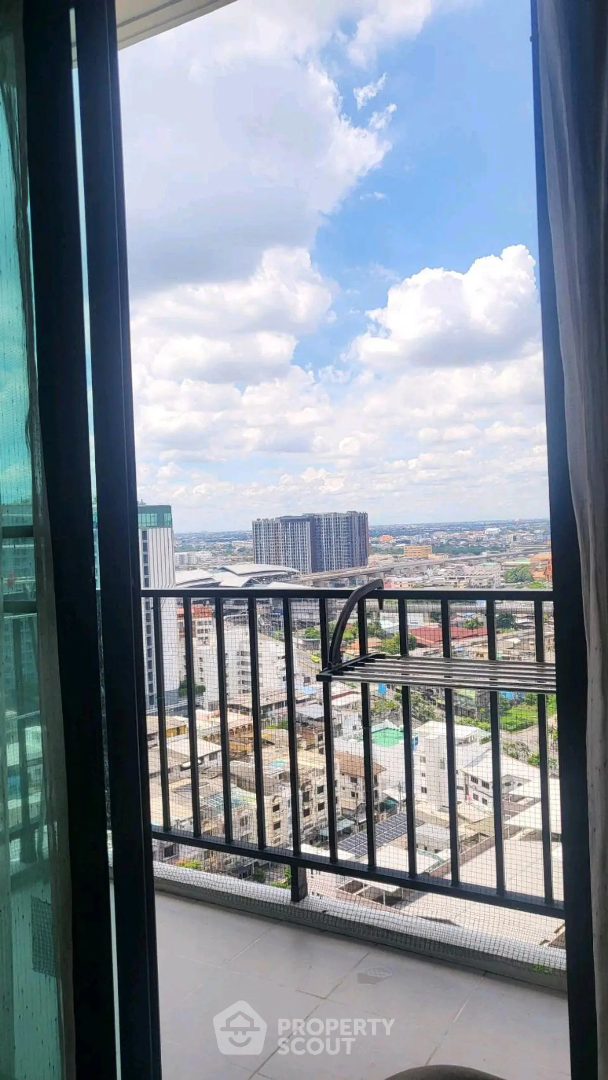 Stunning high-rise balcony view showcasing cityscape and blue skies, perfect for urban living enthusiasts.