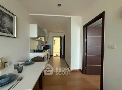 Modern apartment interior with dining area and kitchen, featuring sleek design and contemporary decor.
