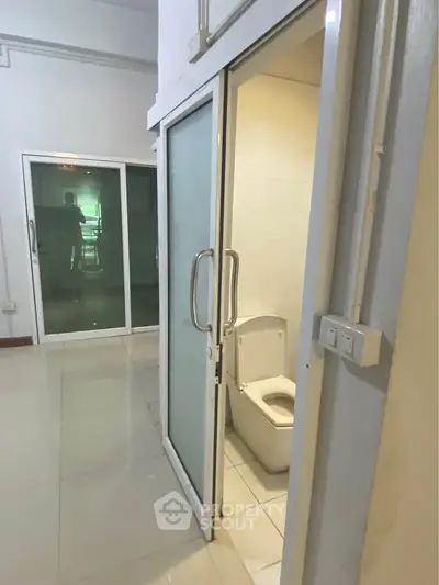 Modern apartment with sliding glass doors and sleek bathroom design.