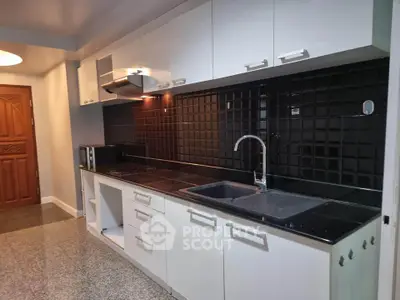 Modern kitchen with sleek black backsplash and white cabinetry