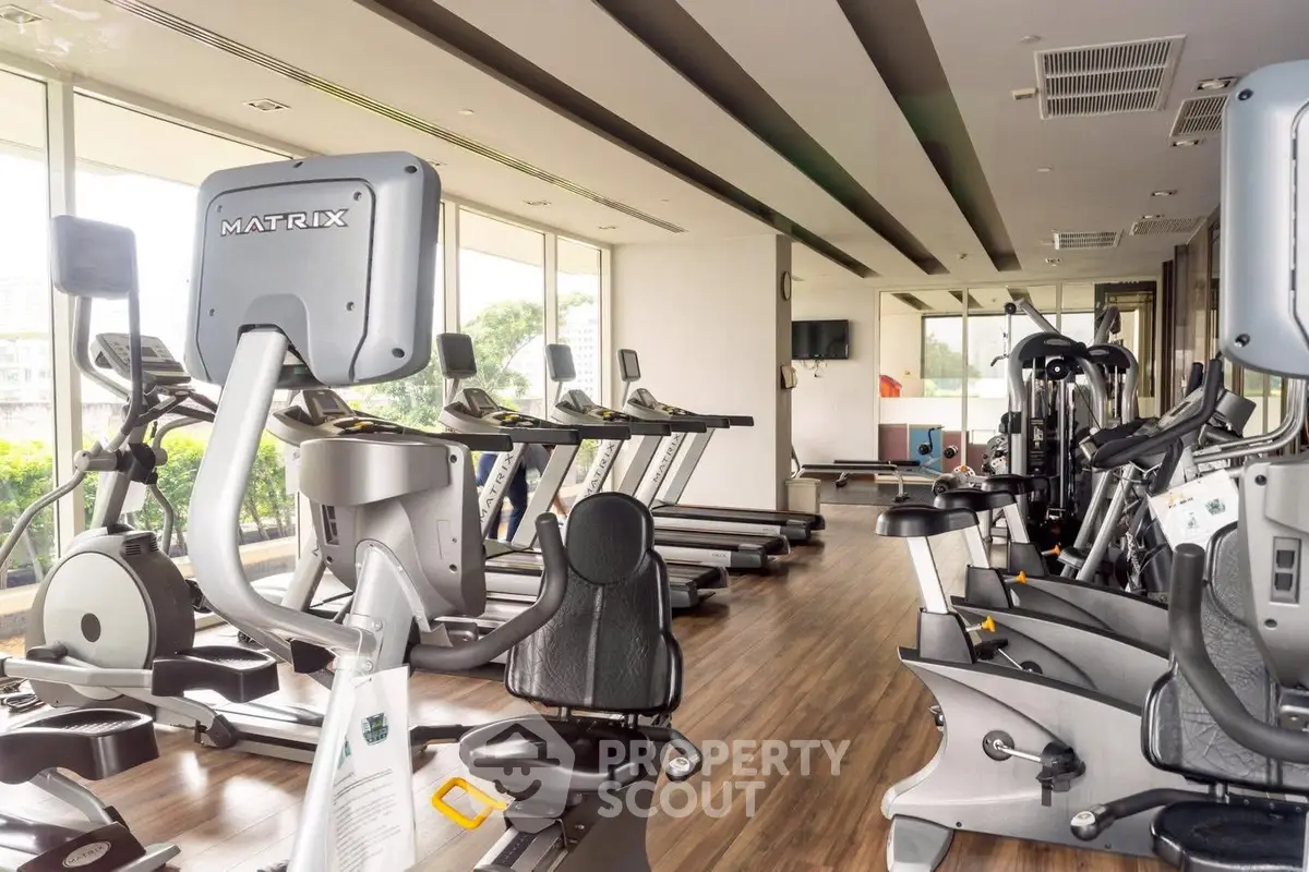 Modern gym with state-of-the-art equipment and large windows for natural light.