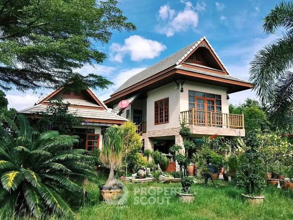 Charming two-story house with lush garden and traditional architecture under a clear blue sky.