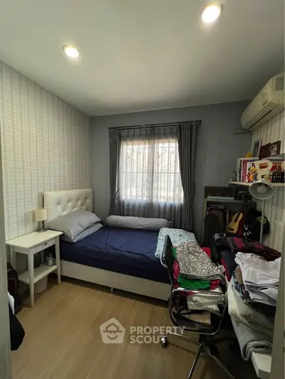 Cozy bedroom with natural light, modern decor, and ample storage space.