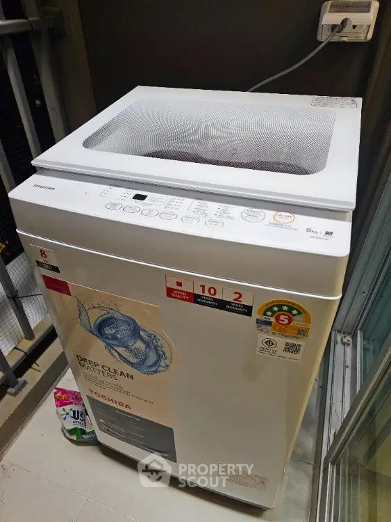 Modern washing machine in a compact laundry area with balcony access.