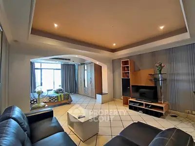 Spacious living room with modern decor and adjacent bedroom view