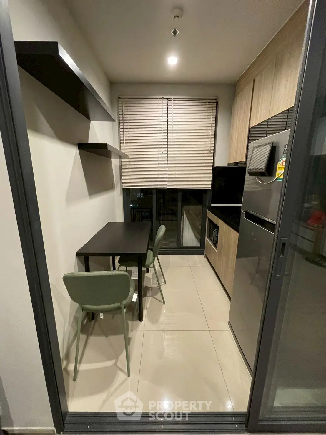 Modern compact kitchen with dining area, featuring sleek appliances and stylish shelving.