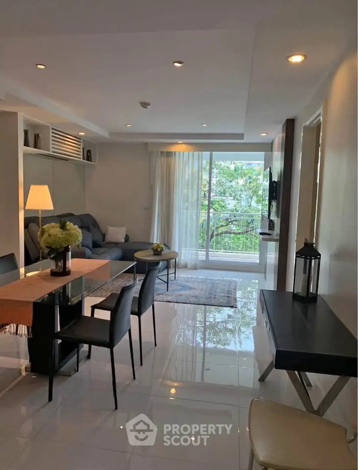 Modern living room with sleek furniture and large windows offering lush garden views.