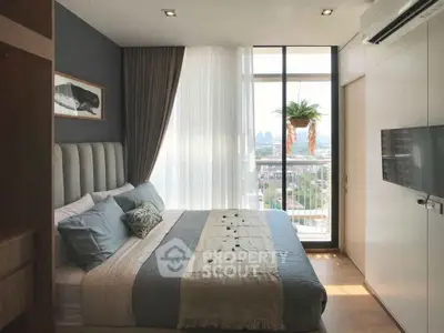 Modern bedroom with large window and city view, featuring stylish decor and cozy bedding.