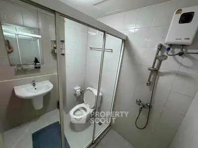 Modern bathroom with shower and sleek fixtures in a compact layout.