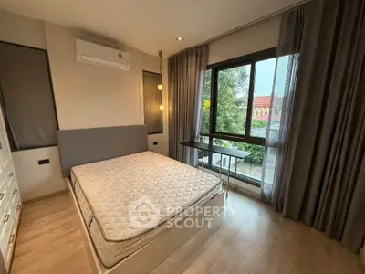 Modern bedroom with large window and natural light, featuring a comfortable bed and stylish decor.