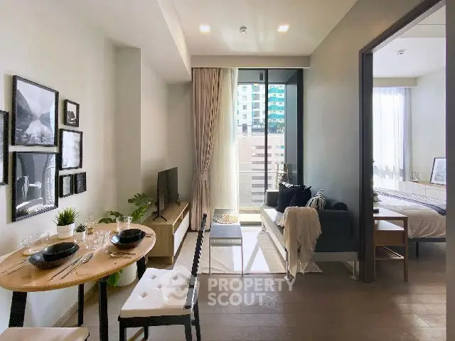 Modern open-plan living room with dining area and balcony view in a stylish apartment.