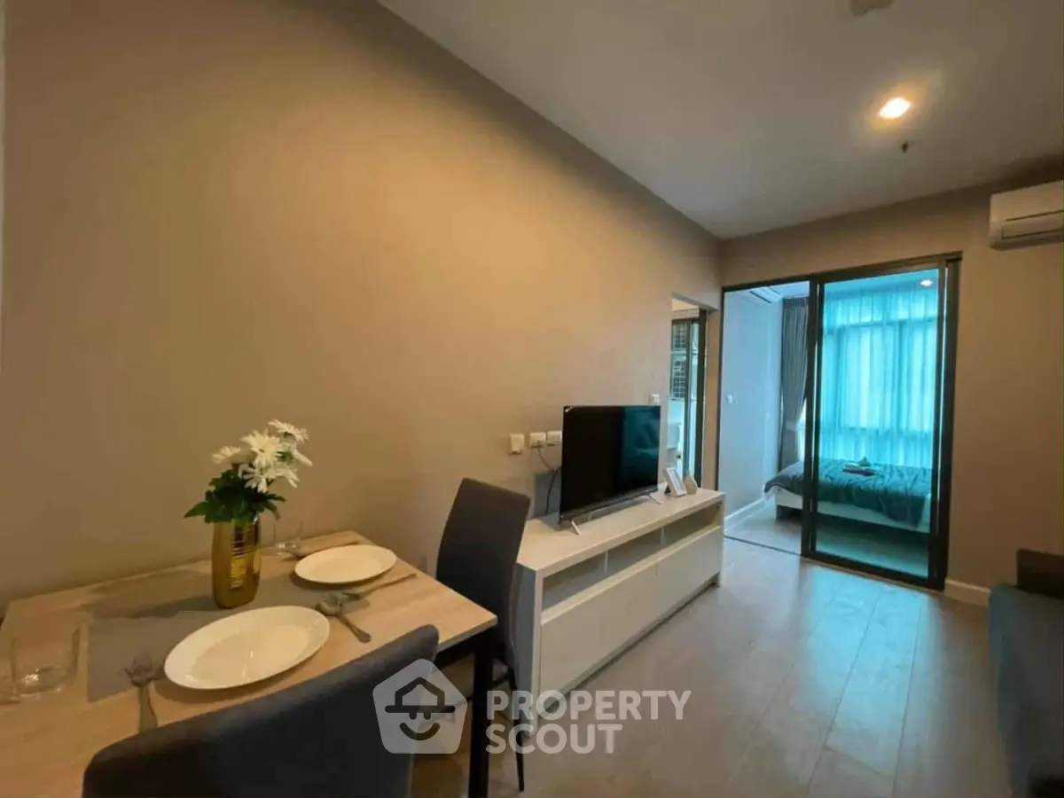 Modern apartment interior with cozy living room and dining area leading to a bedroom.