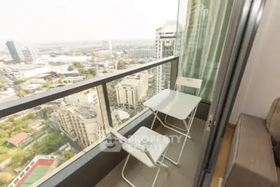 Stunning high-rise balcony with breathtaking cityscape views and cozy seating area.