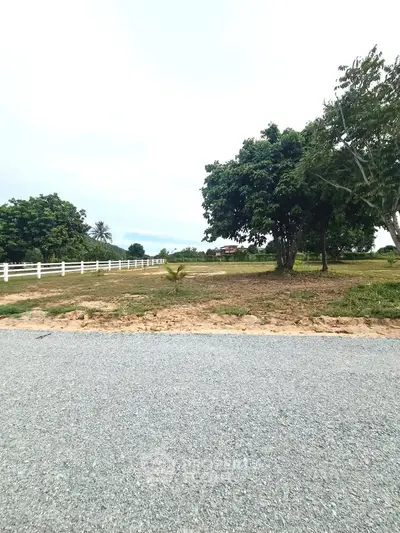 Spacious plot of land with lush greenery and clear skies, perfect for building your dream home.