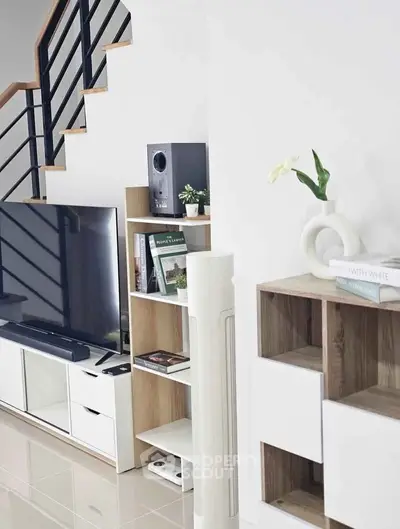Modern living room with sleek TV stand, stylish shelving, and elegant staircase, perfect for contemporary living.