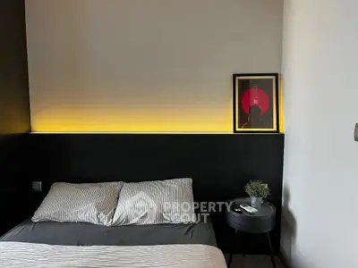 Modern bedroom with stylish lighting and framed artwork, perfect for urban living.