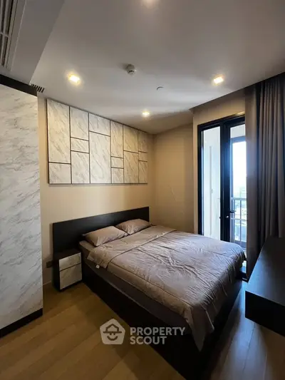 Modern bedroom with stylish decor and balcony access in a luxury apartment.