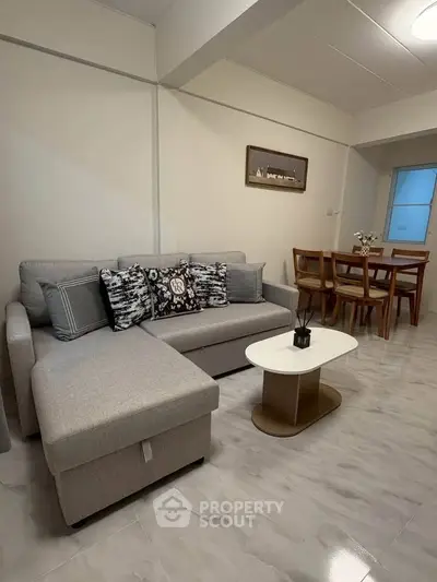 Modern living room with stylish furniture and dining area in open layout apartment.