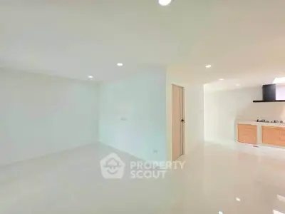 Spacious open-plan living area with modern kitchen and sleek finishes.
