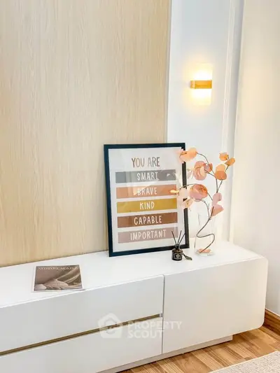 Stylish modern interior with sleek white console and motivational decor in a cozy living space.