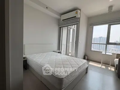 Modern bedroom with large window and city view, featuring a comfortable bed and air conditioning.