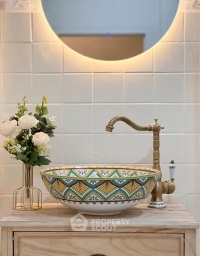Elegant bathroom with decorative sink and modern mirror lighting