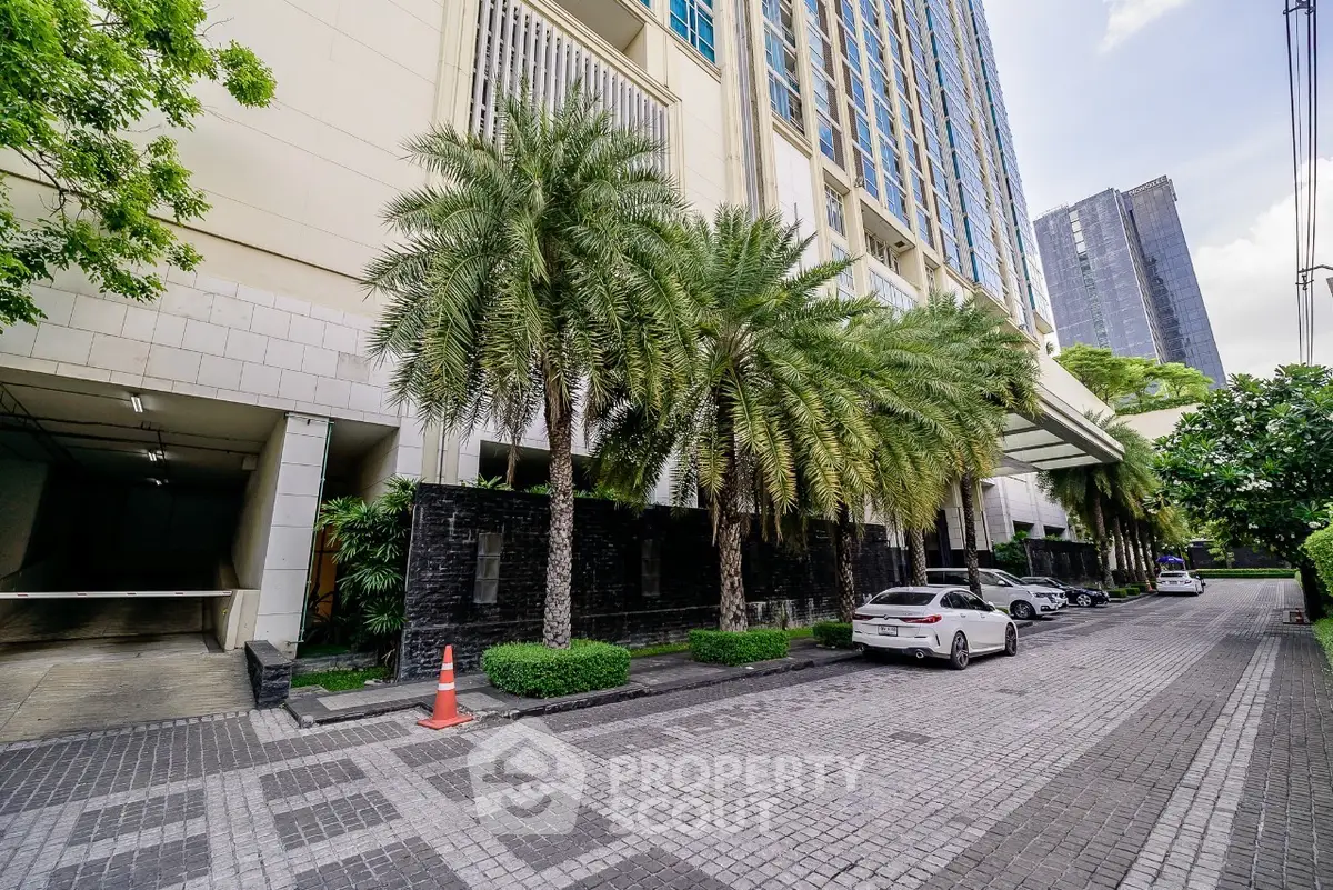 Luxurious high-rise building entrance with palm trees and modern architecture