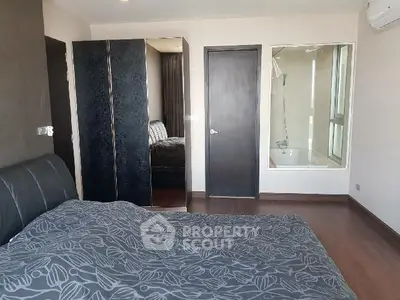 Modern bedroom with ensuite bathroom and sleek black wardrobe