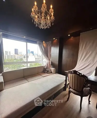 Luxurious living room with elegant chandelier and city view, featuring classic furniture and large windows.