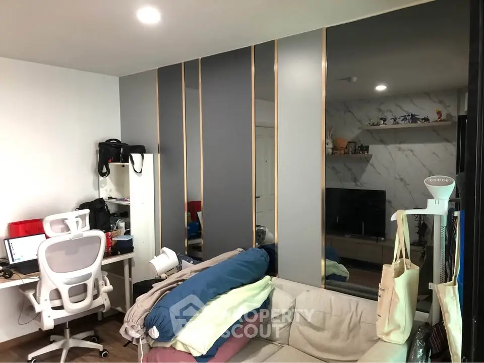 Modern living room with stylish decor and workspace, featuring a sleek desk and comfortable seating.