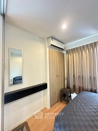 Cozy bedroom with modern decor and air conditioning, featuring a stylish wardrobe and elegant curtains.